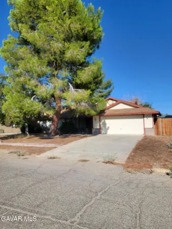 a view of a house with a yard and potted plants