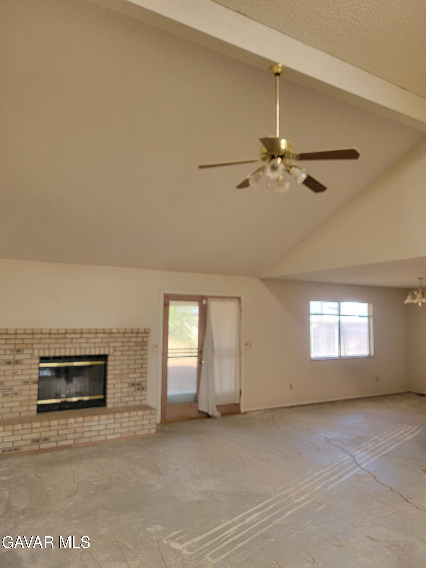 21481 Randsburg Mojave Road California City, CA 93505 - Photo 9 of 28 a view of an empty room with a fireplace and a window