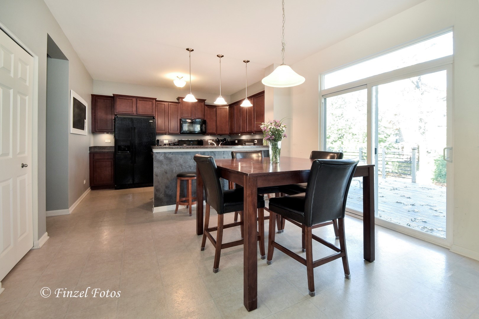 1912 Roger Road Woodstock, IL 60098 - Photo 4 of 21 a dining area with a table chairs and kitchen view