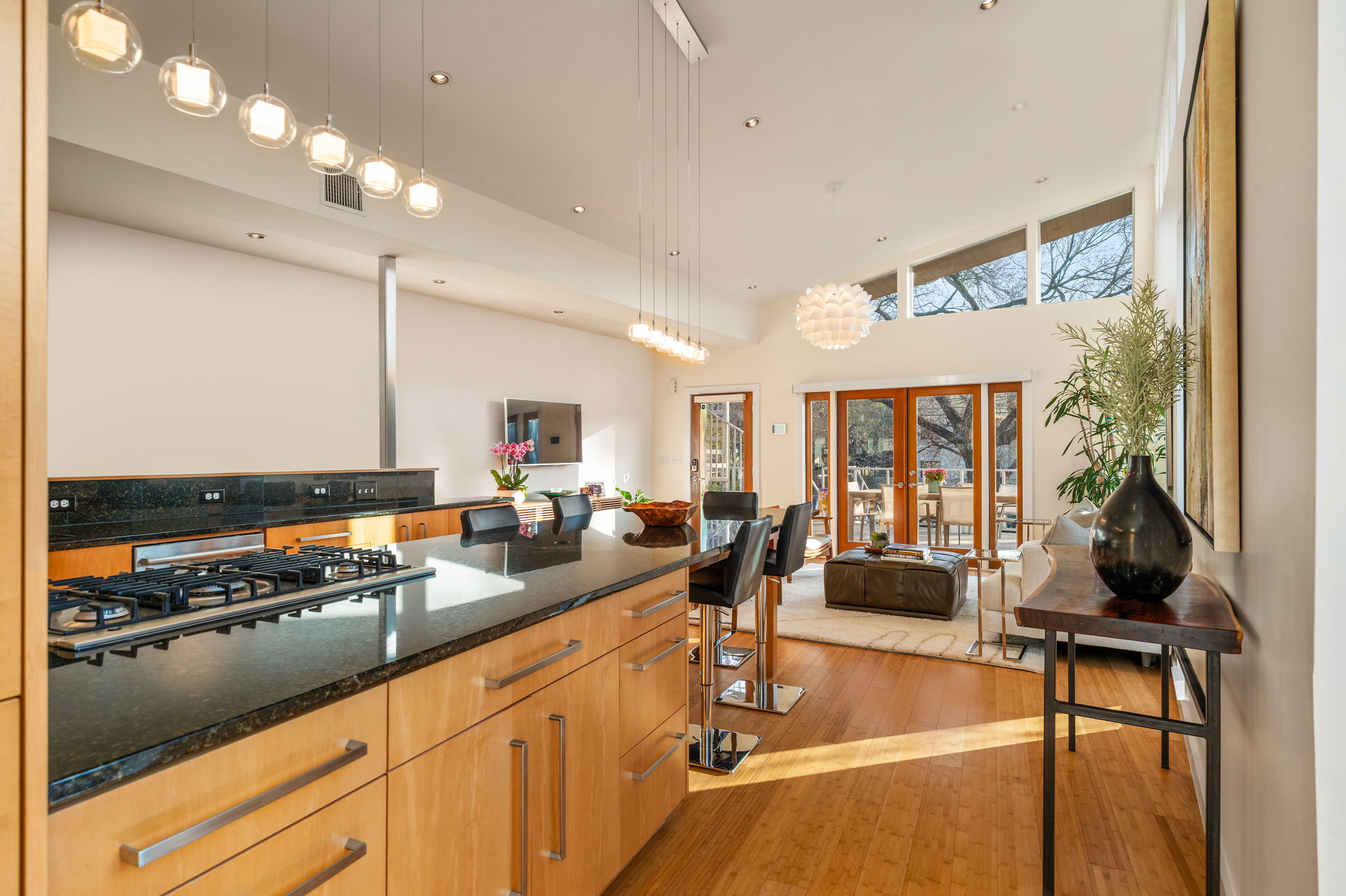 1700 Ravey Street, Unit A Austin, TX 78704 - Photo 39 of 40 Kitchen with light wood finished floors, dark stone counters, french doors, stainless steel gas stovetop, and open floor plan