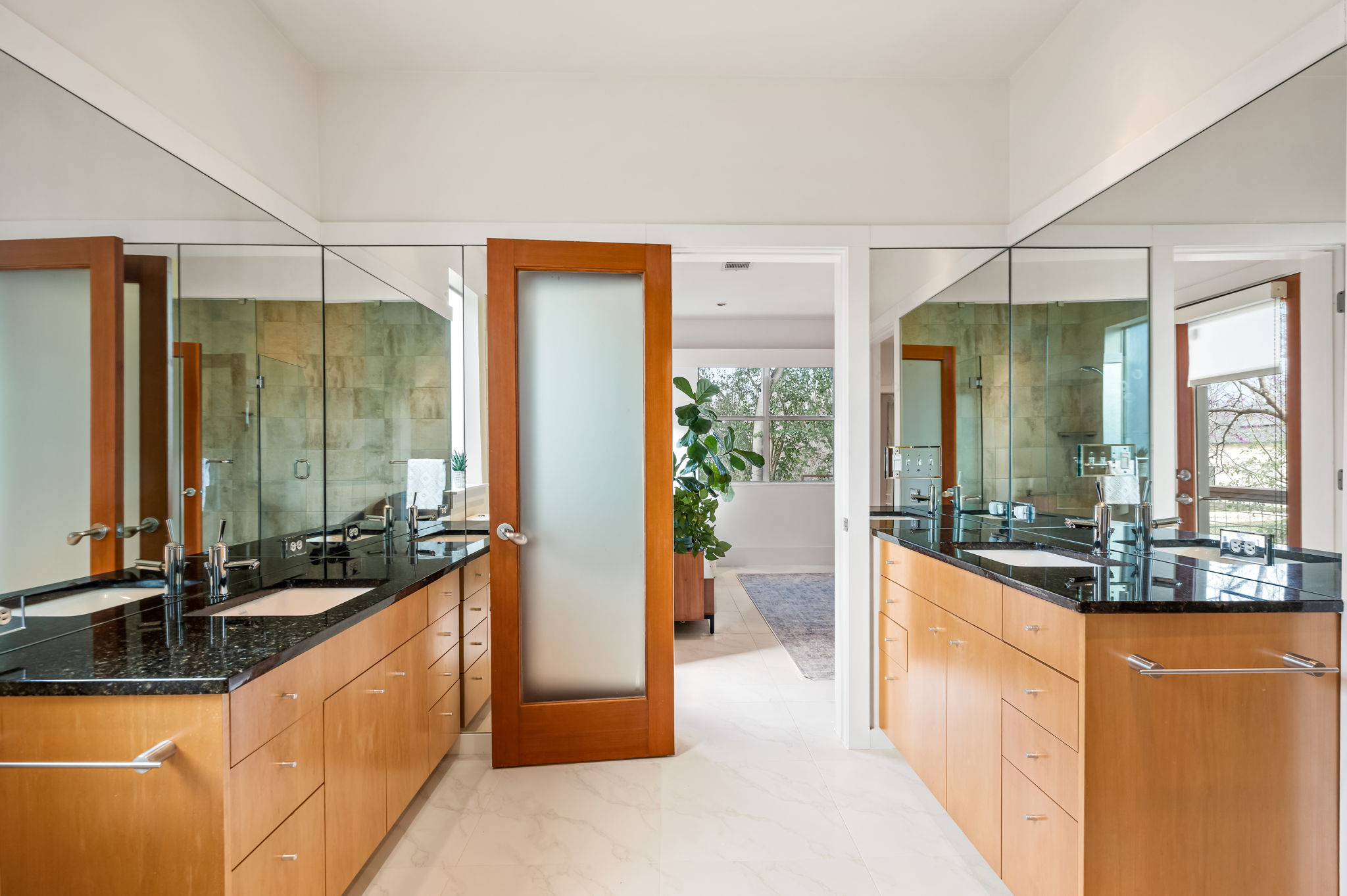 1700 Ravey Street, Unit A Austin, TX 78704 - Photo 28 of 40 Bathroom featuring two vanities, a shower stall, and light marble finish tile floors
