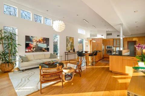 a living room with furniture a flat screen tv and a large window