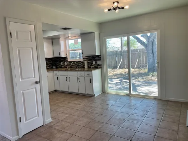 an empty room with windows and ceiling fan