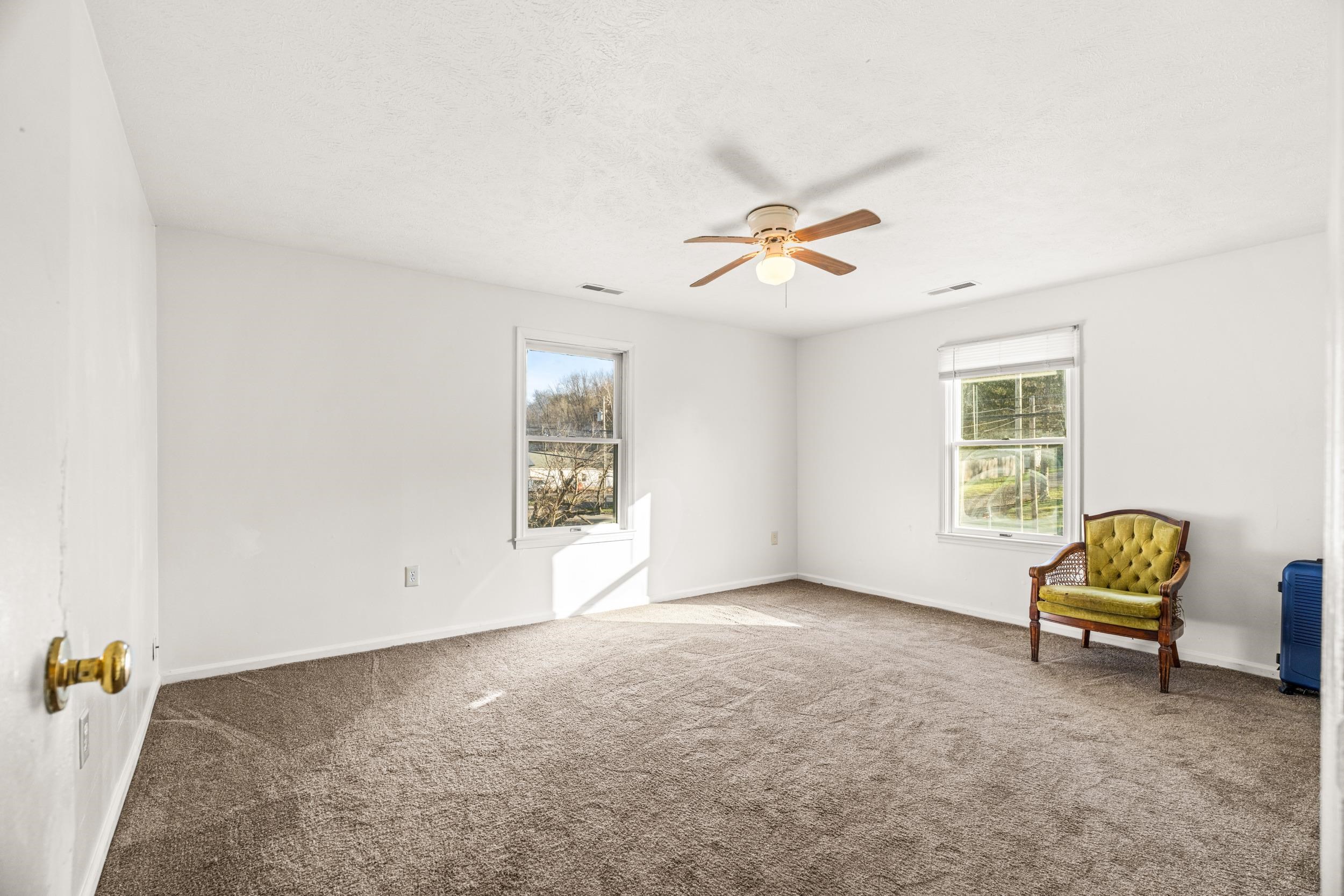 1316 East Main Street Waynesboro, VA 22980 - Photo 27 of 34 an empty room with windows and ceiling fan