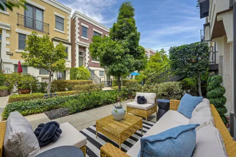 a view of a patio with couches table and chairs and potted plants
