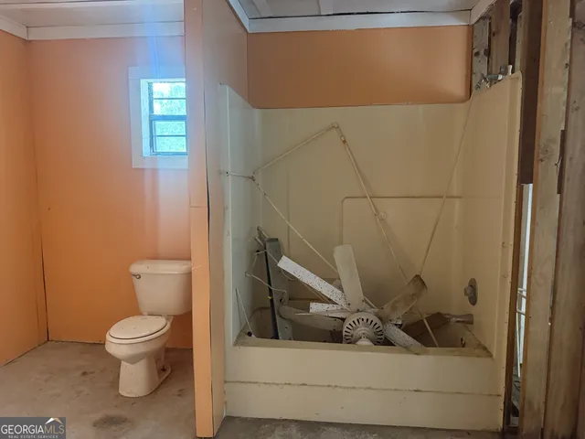 a bathroom with a toilet and a shower