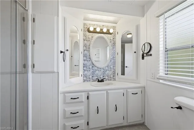 a bathroom with a granite countertop sink a mirror and a vanity