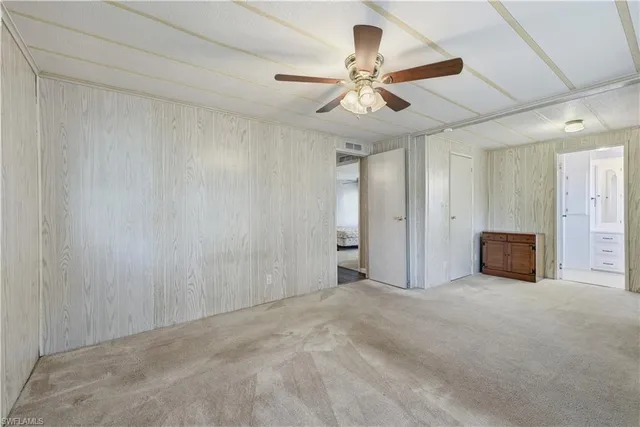 a view of an empty room and chandelier fan