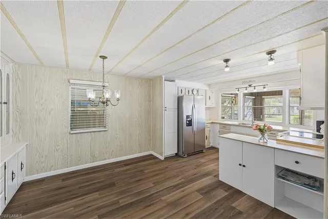 a large white kitchen with a sink shower and wooden floor