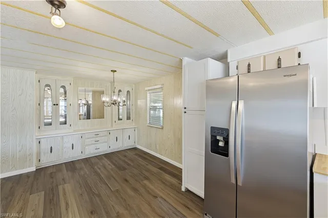 a kitchen with stainless steel appliances a refrigerator and a wooden floor
