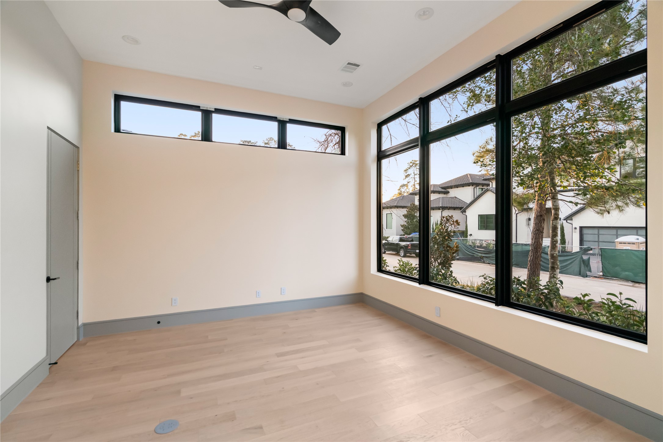 47 Pronghorn Place Spring, TX 77389 - Photo 22 of 44 This bright room features large windows offering ample natural light and views of the neighborhood. It has light wood flooring, neutral walls, and a modern ceiling fan, creating an airy, welcoming space.