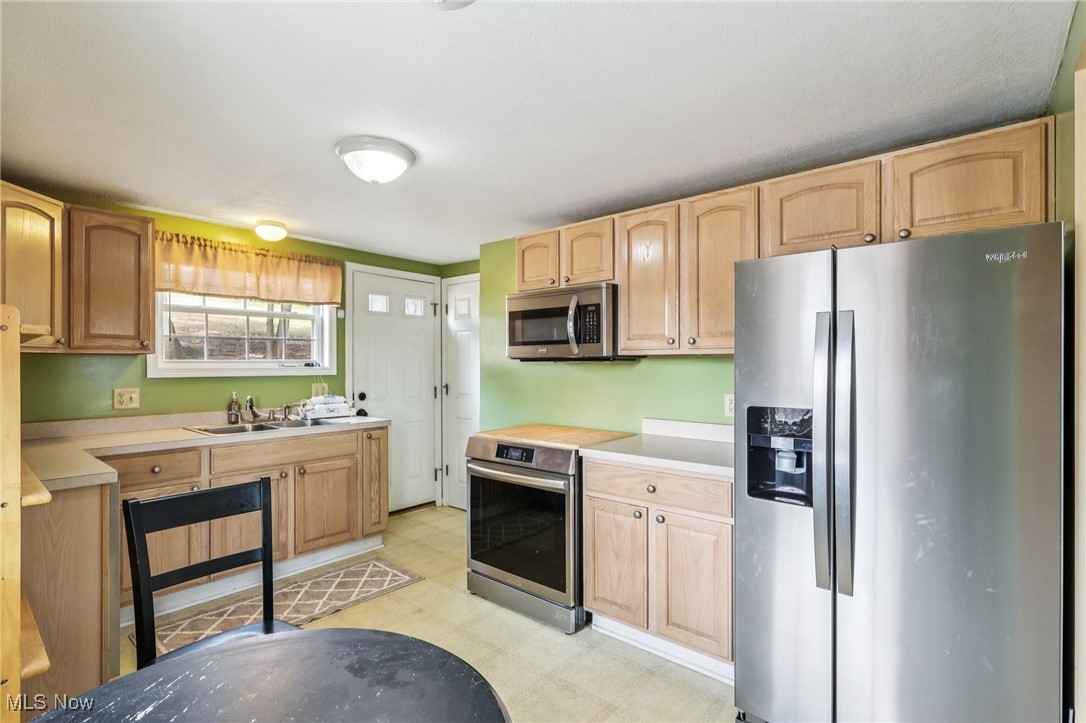 23 Lane Street Rittman, OH 44270 - Photo 24 of 34 Kitchen with stainless steel appliances, light countertops, light floors, and light brown cabinetry