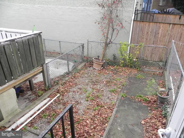 a view of a backyard with wooden fence