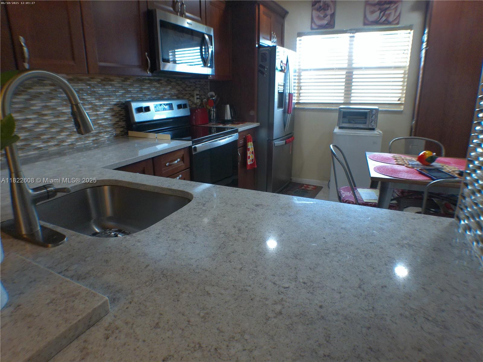 8834 West McNab Road, Unit 302 Tamarac, FL 33321 - Photo 12 of 25 a kitchen with a sink cabinets and a window