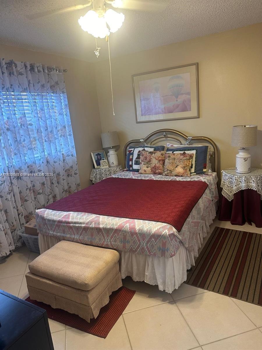8834 West McNab Road, Unit 302 Tamarac, FL 33321 - Photo 13 of 25 a bedroom with a bed and a chandelier