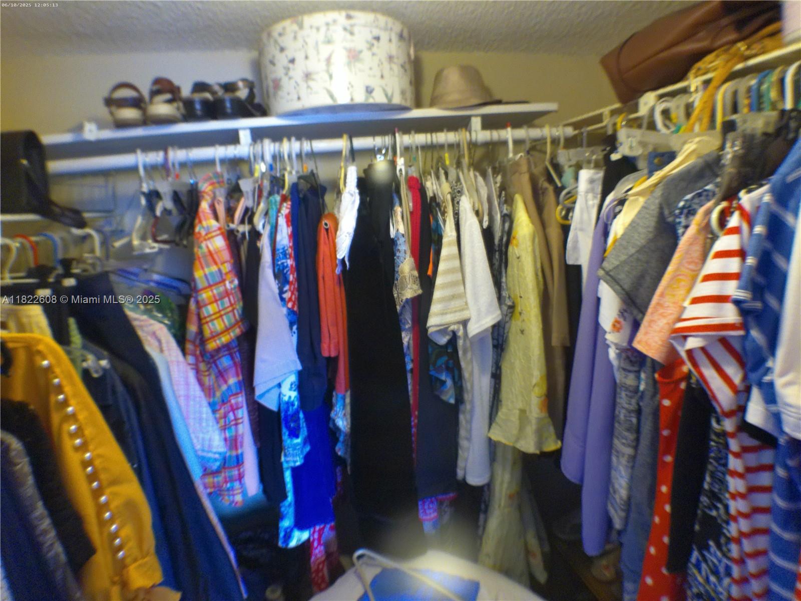8834 West McNab Road, Unit 302 Tamarac, FL 33321 - Photo 17 of 25 a view of walk in closet with clothes and shoes