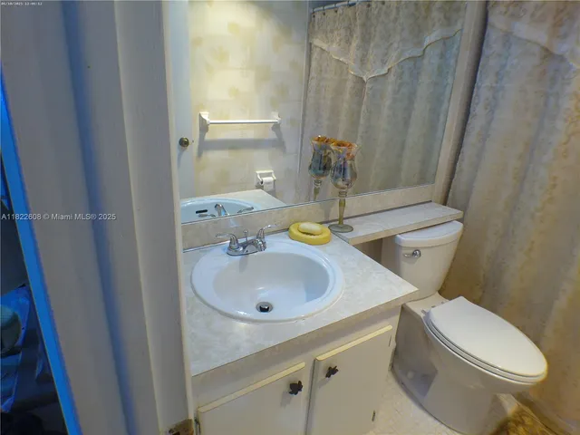 a bathroom with a sink a toilet and shower curtain