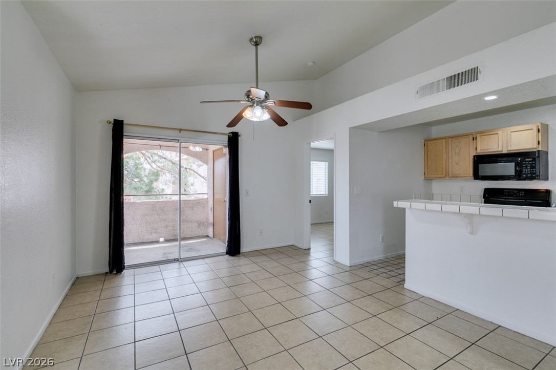 7570 West Flamingo Road, Unit 252 Las Vegas, NV 89147 - Photo 37 of 44 A well-lit living area features tiled flooring and a sliding door leading to an outdoor balcony space.