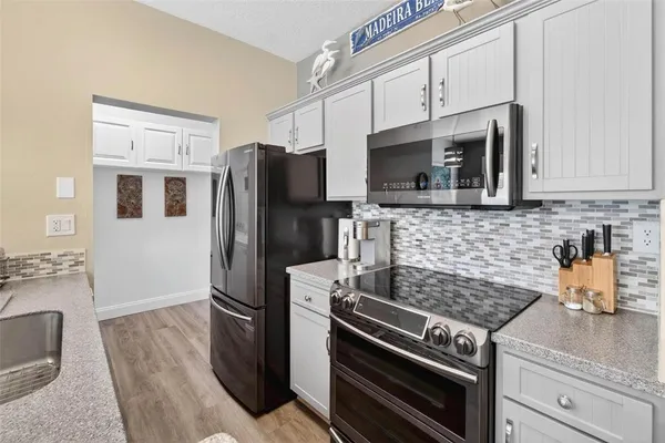 a kitchen with stainless steel appliances a stove microwave and refrigerator