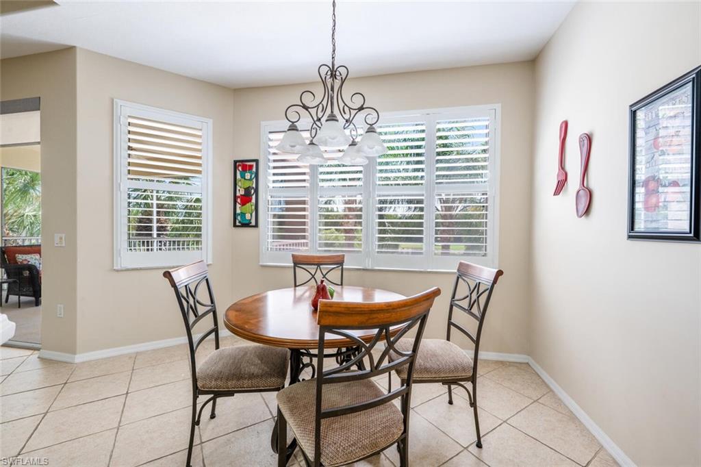4630 Winged Foot Court, Unit 202 Naples, FL 34112 - Photo 11 of 32 Dining room with light tile patterned floors, a chandelier, and a healthy amount of sunlight