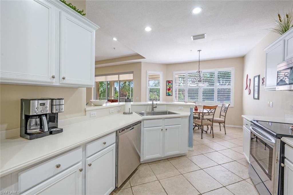 4630 Winged Foot Court, Unit 202 Naples, FL 34112 - Photo 14 of 32 Kitchen with white cabinetry, a sink, visible vents, stainless steel appliances, and a peninsula