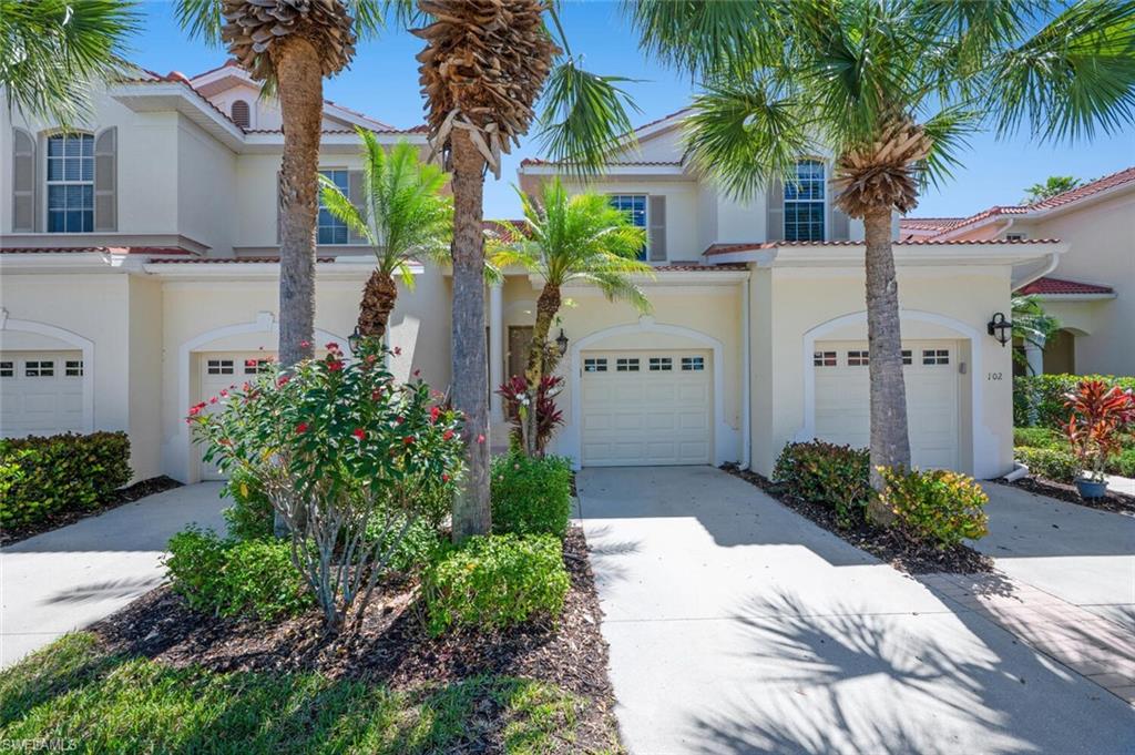 4630 Winged Foot Court, Unit 202 Naples, FL 34112 - Photo 2 of 32 View of front of house featuring concrete driveway, an attached garage, and stucco siding