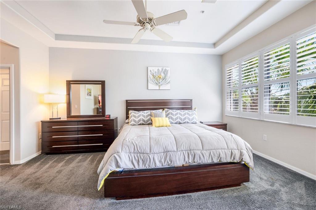 4630 Winged Foot Court, Unit 202 Naples, FL 34112 - Photo 21 of 32 Bedroom with a raised ceiling, carpet floors, and baseboards