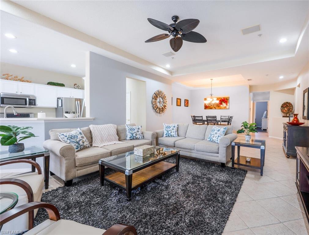 4630 Winged Foot Court, Unit 202 Naples, FL 34112 - Photo 5 of 32 Living room with recessed lighting, light tile patterned floors, ceiling fan with notable chandelier, and a raised ceiling