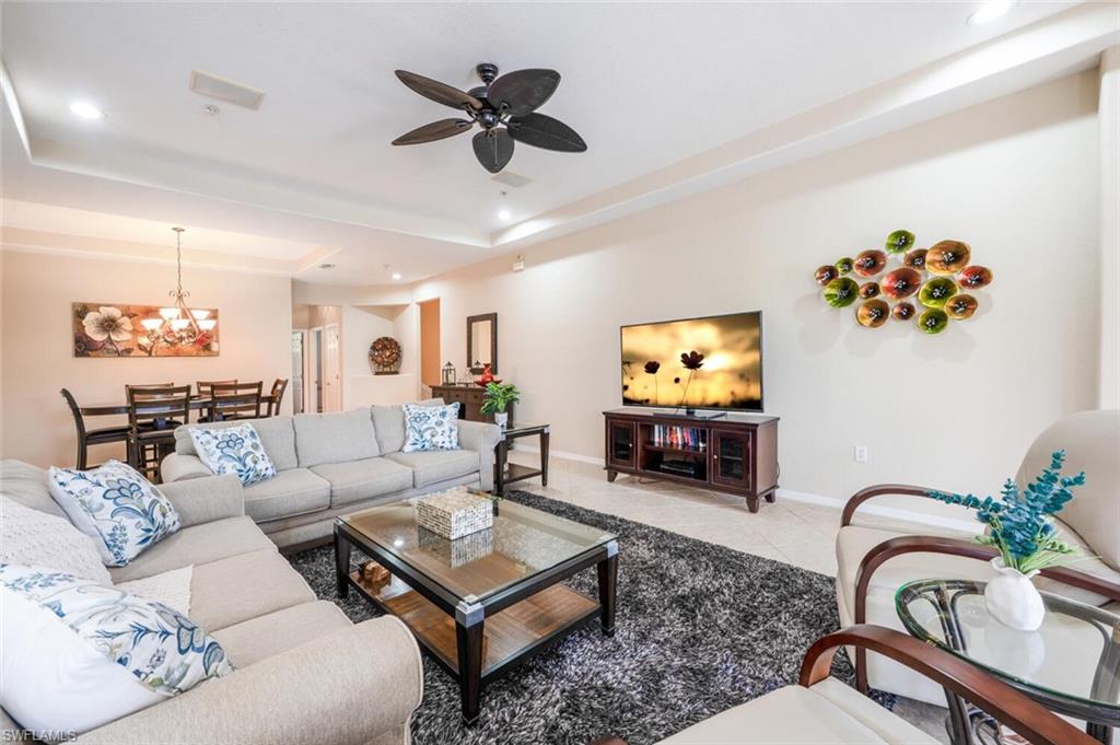 4630 Winged Foot Court, Unit 202 Naples, FL 34112 - Photo 6 of 32 Living area featuring recessed lighting, a tray ceiling, ceiling fan with notable chandelier, and baseboards