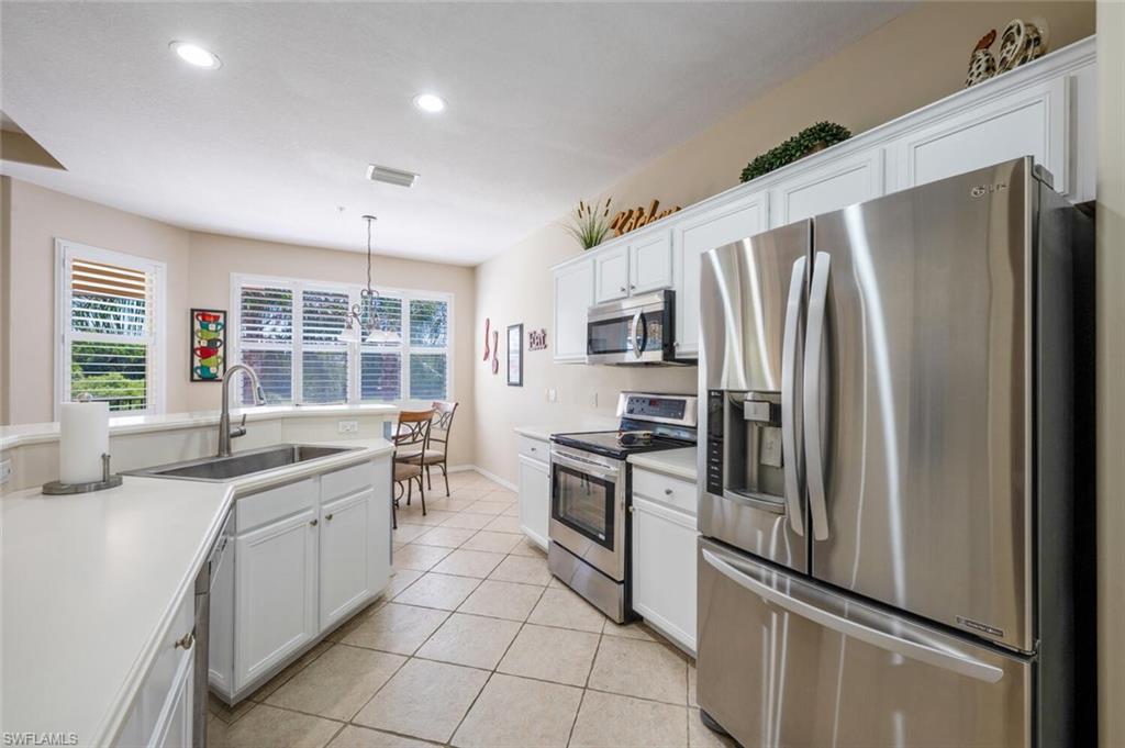 4630 Winged Foot Court, Unit 202 Naples, FL 34112 - Photo 10 of 32 Kitchen with white cabinets, a sink, stainless steel appliances, light tile patterned flooring, and recessed lighting