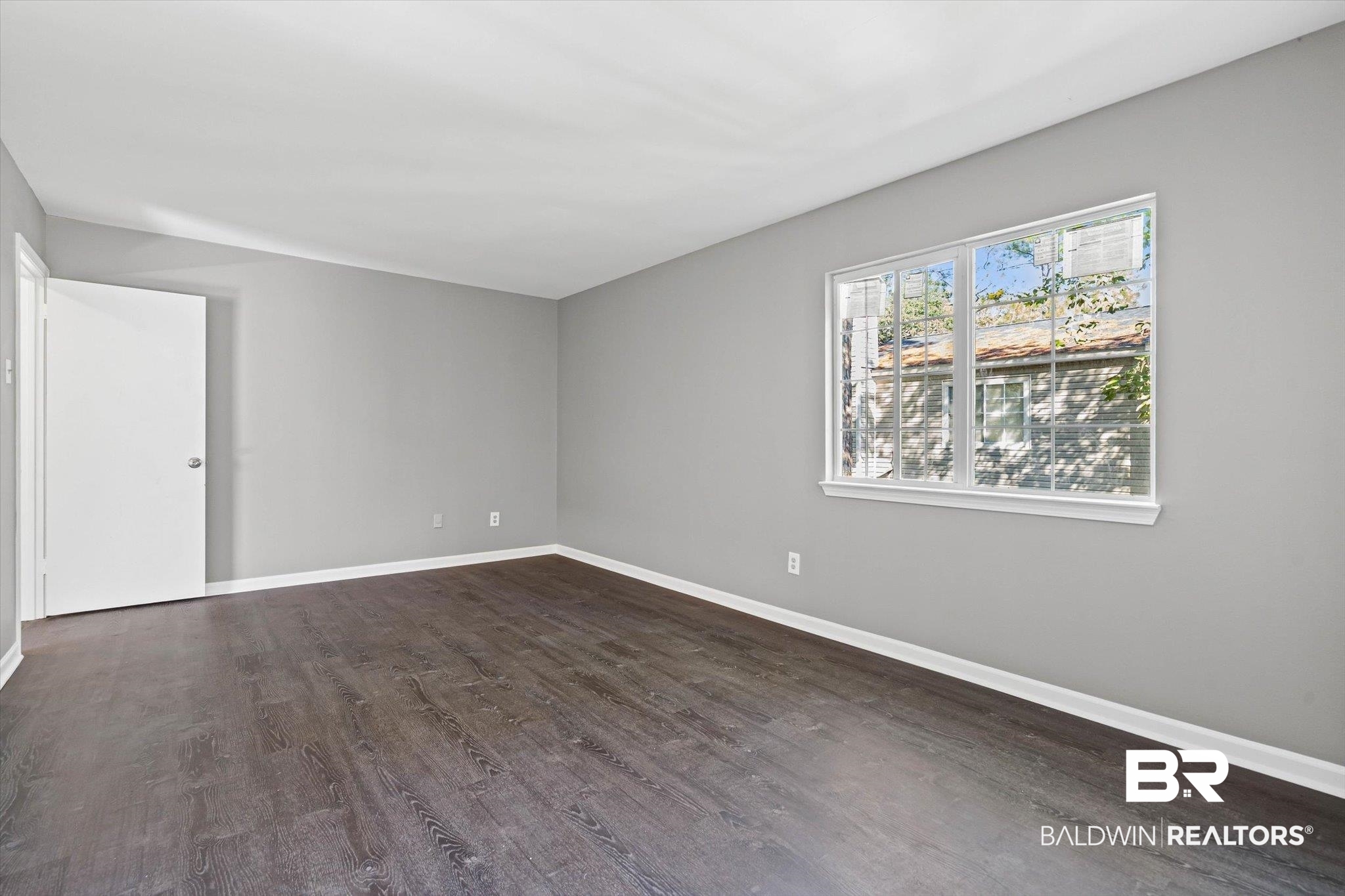 6701 Dickens Ferry Road, Unit 100 Mobile, AL 36608 - Photo 14 of 24 Empty room featuring dark wood-type flooring and baseboards