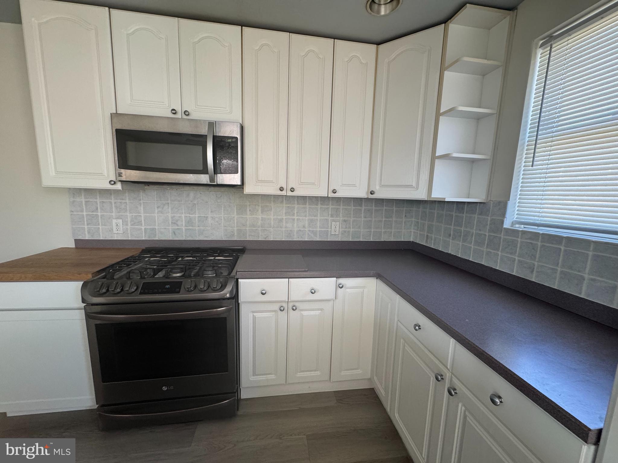 4215 Lansing Street Philadelphia, PA 19136 - Photo 5 of 14 a kitchen with granite countertop white cabinets and stainless steel appliances