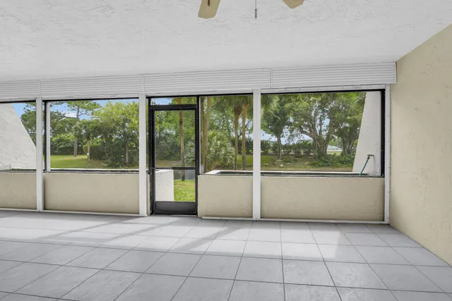 an empty room with floor to ceiling windows and yard