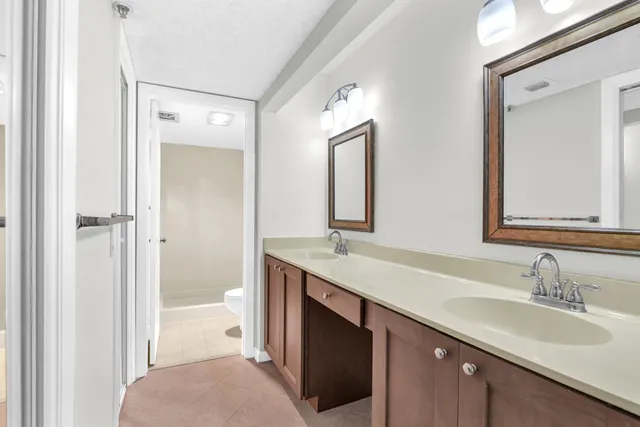 a en suite bathroom with a double vanity sink a mirror and a shower