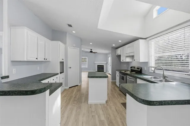 a kitchen with granite countertop a sink stove and refrigerator