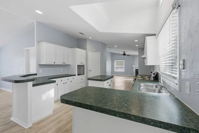 a large kitchen with stainless steel appliances granite countertop a sink a stove and a refrigerator