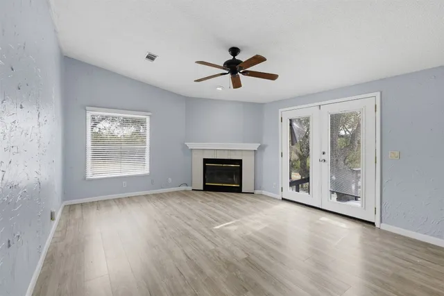 a view of empty room with wooden floor and fireplace