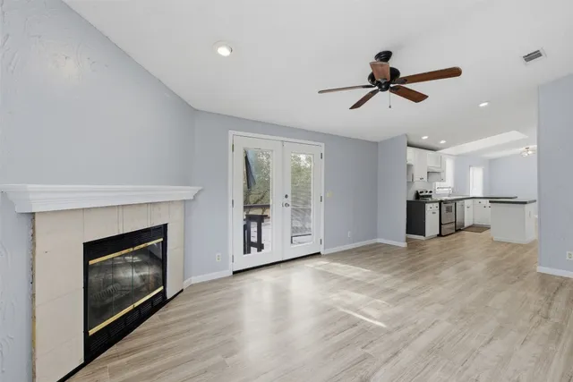 a view of empty room with wooden floor and fireplace