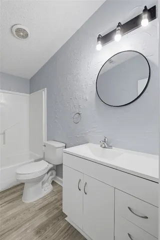a bathroom with a toilet a sink and mirror
