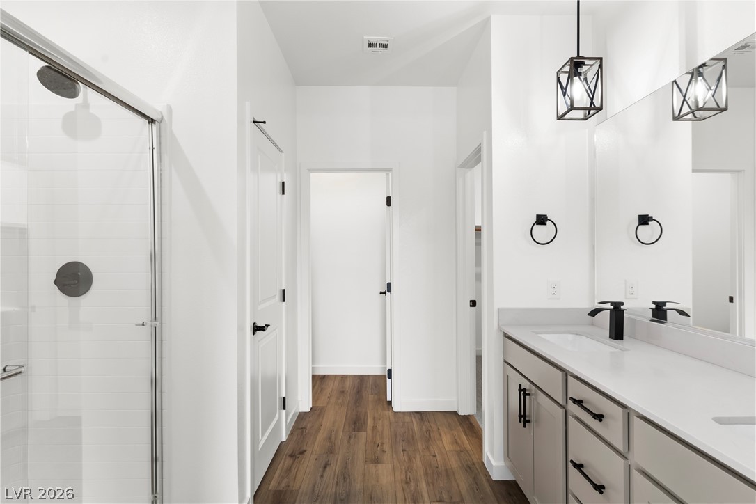 633 Infinity Rdg Street Las Vegas, NV 89138 - Photo 12 of 36 Bathroom featuring a stall shower, dark wood-style flooring, and double vanity