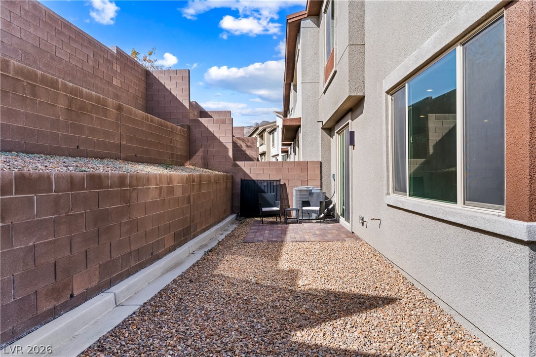 633 Infinity Rdg Street Las Vegas, NV 89138 - Photo 22 of 36 View of side of property with a fenced backyard, a patio area, and stucco siding