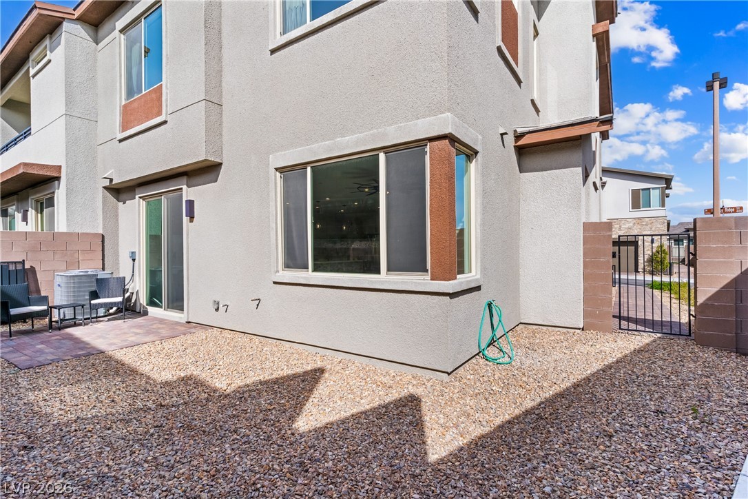 633 Infinity Rdg Street Las Vegas, NV 89138 - Photo 24 of 36 Back of property with stucco siding, a gate, and a patio