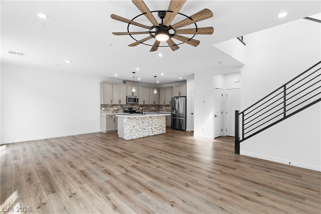 633 Infinity Rdg Street Las Vegas, NV 89138 - Photo 33 of 36 Kitchen featuring open floor plan, a kitchen island with sink, stainless steel appliances, and a ceiling fan