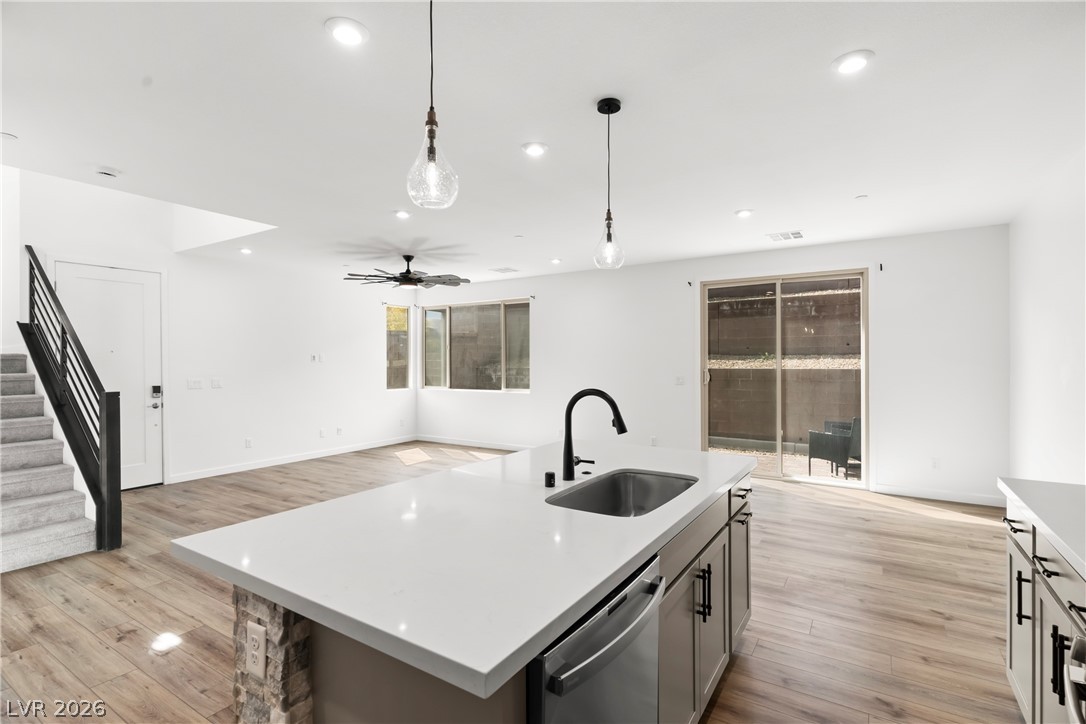 633 Infinity Rdg Street Las Vegas, NV 89138 - Photo 34 of 36 Kitchen with light wood finished floors, an island with sink, ceiling fan, dishwasher, and open floor plan