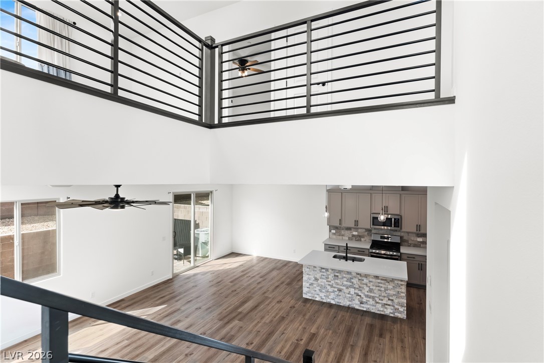 633 Infinity Rdg Street Las Vegas, NV 89138 - Photo 6 of 36 Unfurnished living room with a ceiling fan, dark wood-style flooring, and a high ceiling