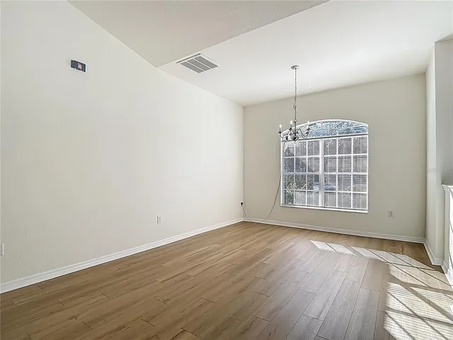 a view of a kitchen with wooden floor and a window