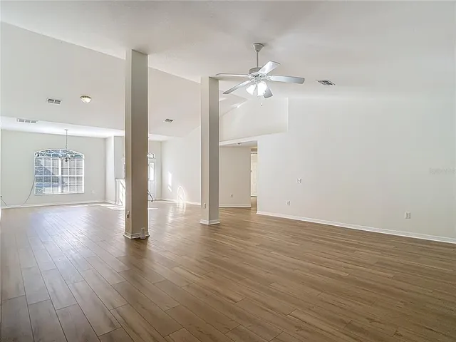 a kitchen with stainless steel appliances granite countertop a stove top oven a sink dishwasher and a refrigerator with wooden floor