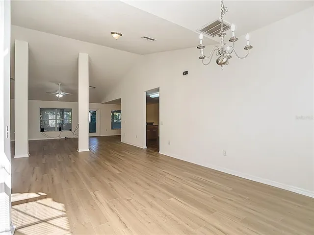 a view of a livingroom with wooden floor and a ceiling fan