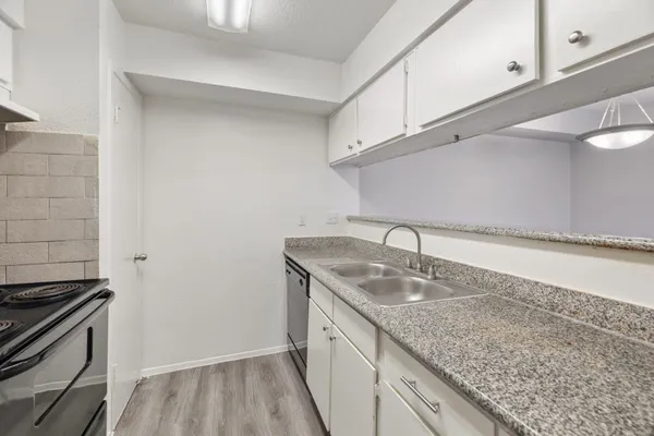 a kitchen with a sink stove and cabinets