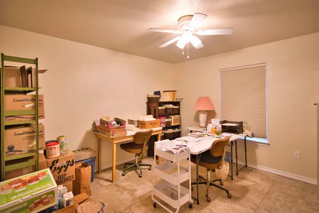 a room with furniture a ceiling fan and a window